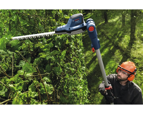 Personne taillant une haie avec un taille-haie télescopique sans fil Bosch