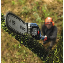 Logo Bosch sur une tronçonneuse à batterie coupant une branche