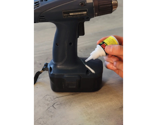 Une perceuse endommagée est réparée avec de la colle.