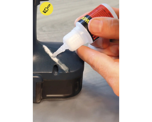 Une personne applique de la colle sur une pièce.