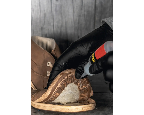 Application de colle sur une chaussure pour réparer la semelle