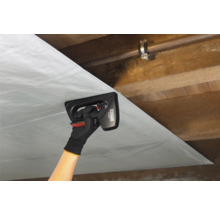 Eine Person befestigt Dampfsperrfolie mit einem Handtacker an einer Holzdecke.