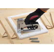 Hand mit Tacker auf Keilrahmen