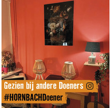 Dekoratives Wohnzimmer mit Gemälde, Tischlampen und Zimmerpflanzen.