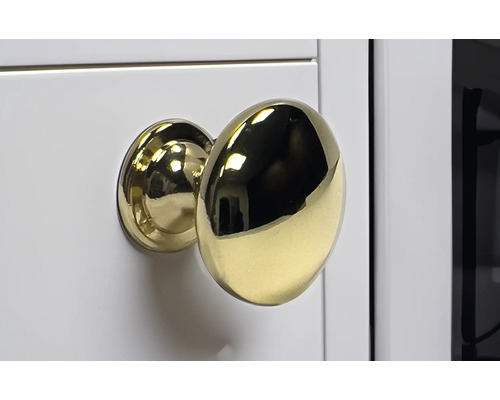 Goldener Möbelknopf an weisser Oberfläche