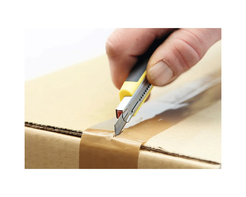 Hand schneidet mit einem Teppichmesser ein Paket auf.