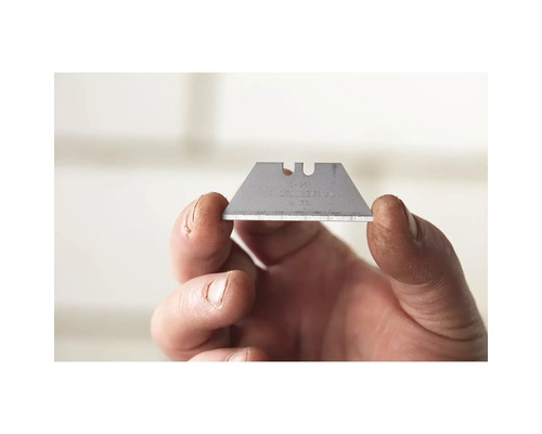 Eine Trapezklinge wird von einer Hand gehalten.