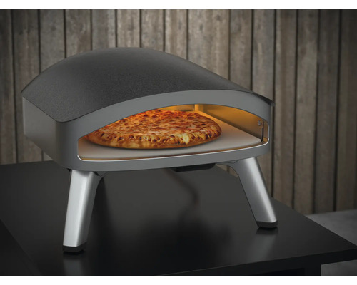 Pizzaofen mit Pizza im Innenraum auf einem Tisch