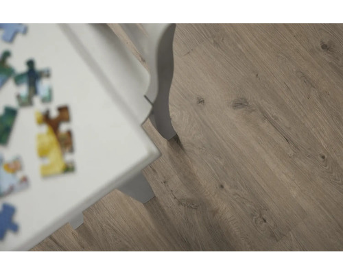 Nahaufnahme von Laminatboden mit Holzoptik und weissem Tischbein