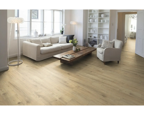 Heller Wohnraum mit Holzboden, Sofa, Sessel und Regal.