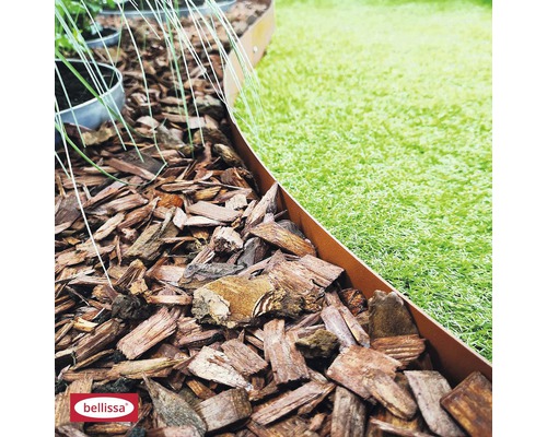 Bordure de parterre en métal entre le paillis d''écorce et la pelouse