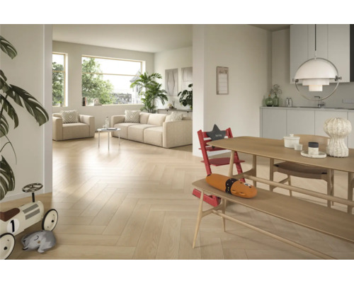 Heller Wohnraum mit Parkettboden im Fischgrätmuster, Sofa, Sessel und Esstisch mit Kinderstuhl