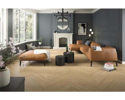 Salon avec parquet à chevrons, canapé en cuir et cheminée