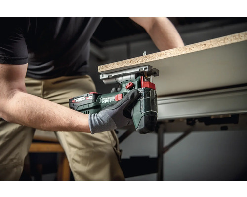 Artisan utilisant une cisaille à tôle sans fil Metabo pour couper une pièce