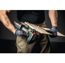 Artisan sciant une planche avec une scie sauteuse sans fil Metabo