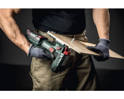 Artisan sciant une planche avec une scie sauteuse sans fil Metabo