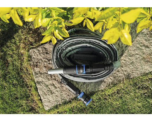 Tuyau d''arrosage flexible sur une pierre dans le jardin