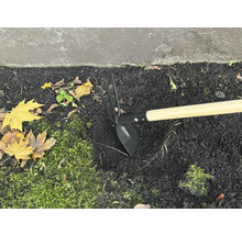 Sarcloir de jardin avec manche en bois dans un parterre