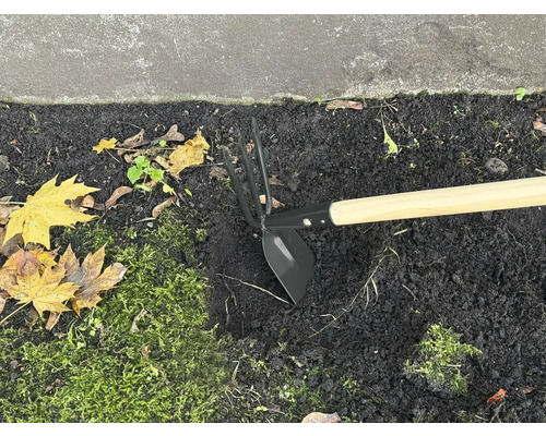 Sarcloir de jardin avec manche en bois dans un parterre