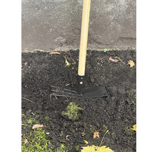 Houe de jardin avec manche en bois dans le sol