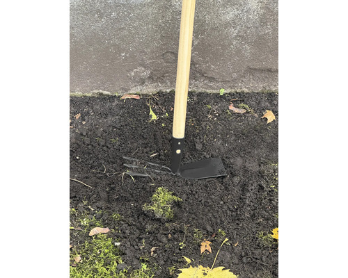 Houe de jardin avec manche en bois dans le sol