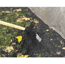 Houe de jardin avec manche en bois utilisée dans le sol du jardin.