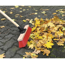 Balai rassemblant les feuilles d''automne sur le pavé