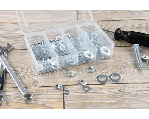 Boîte d''assortiment avec rondelles, clé à molette, tournevis, vis et écrou sur une table en bois