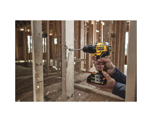 Eine Person bohrt mit einem Akku-Bohrschrauber ein Loch in ein Holzstück.