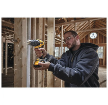 Artisan utilisant une perceuse-visseuse sans fil DeWalt dans une construction brute.