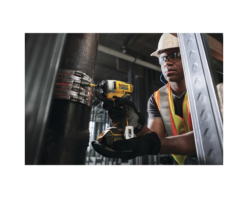 Ein Handwerker befestigt mit einem Akku-Schlagschrauber eine Rohrschelle an einem Rohr.