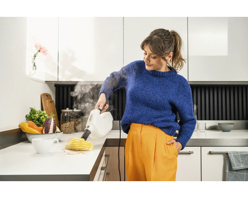 Femme nettoie une table de cuisine avec un nettoyeur vapeur