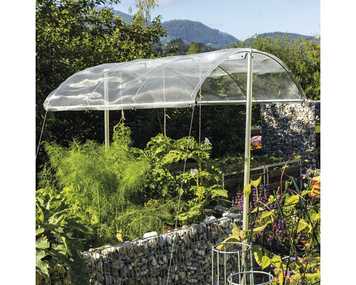 Pflanzenbeet mit Schutznetz und Metallrahmen im Garten