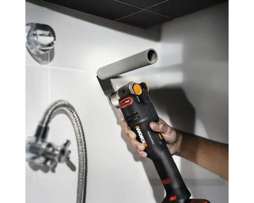 Ein Multifunktionswerkzeug schneidet ein Rohr in einem Badezimmer.