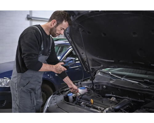 Un mécanicien effectue un diagnostic sur un moteur de voiture à l''aide d''un appareil de diagnostic.