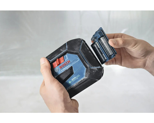 Logo Bosch. Une personne remplace les piles d''un laser lignes croisées.