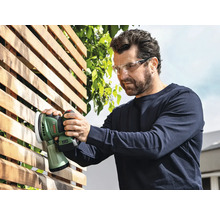 Mann schleift Holzzaun mit einem Akku-Exzenterschleifer der Marke Bosch und trägt dabei eine Schutzbrille.