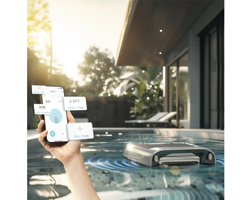 Personne contrôlant un robot de nettoyage de piscine avec un smartphone dans une piscine extérieure
