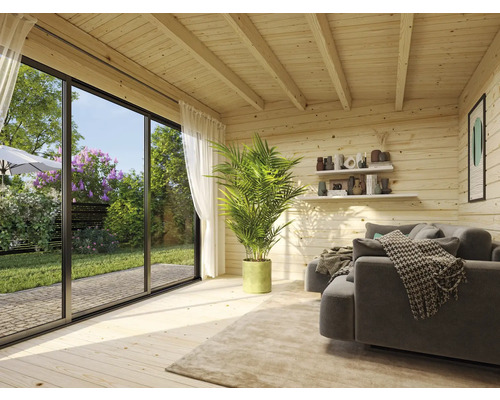 Vue intérieure d''une maison en bois avec canapé, plante et porte coulissante donnant sur le jardin