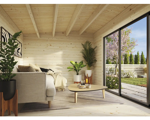 Helle Holzhütte mit Sofa, Tisch, Pflanzen und großem Fenster mit Blick in den Garten.