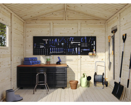 Atelier avec établi, mur d''outils et outils de jardin dans une cabane de jardin en bois.