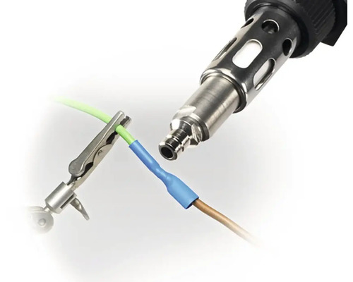 Pistolet thermique reliant deux câbles avec gaine thermorétractable, fixée par une pince crocodile