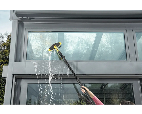 Nettoyage des vitres avec un lave-vitre sur une véranda