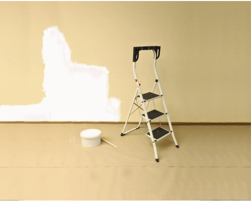 Wandrenovierung mit Farbe, Leiter und Farbbehälter