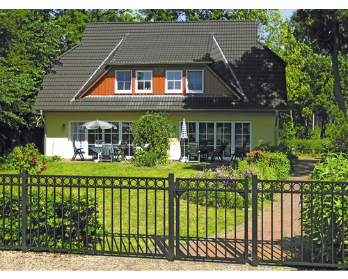 Einfamilienhaus mit Garten, Metallzaun und Gartenmöbeln
