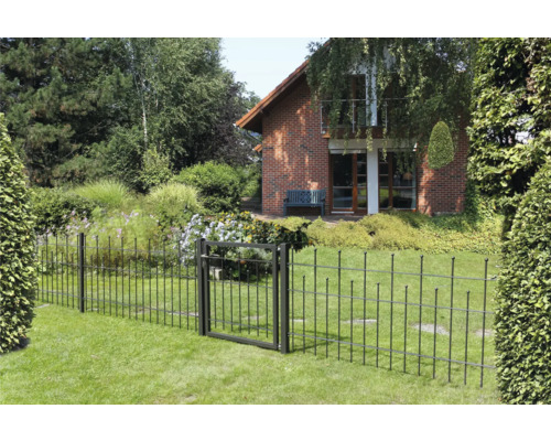 Gartenszene mit Metallzaun und Gartentor vor einem Wohnhaus