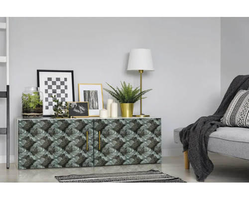 Dekoratives Sideboard mit Pflanzenmuster, Lampe und Bildern in einem Wohnraum