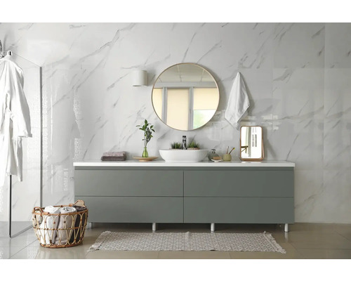 Salle de bain moderne avec meuble-lavabo, miroir et accessoires devant un mur en marbre