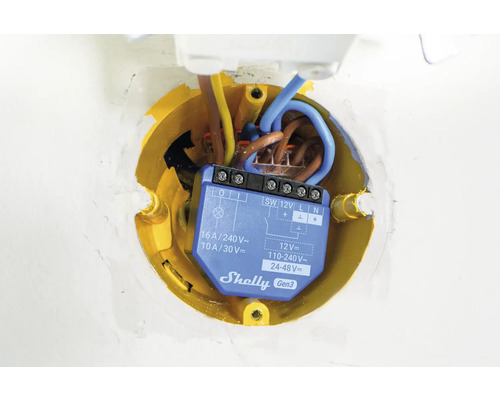 Interrupteur électrique dans une boîte de jonction jaune avec des câbles