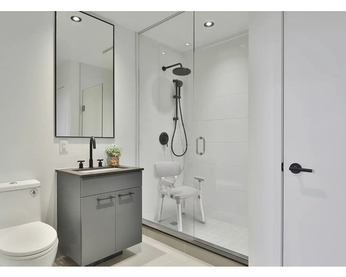 Salle de bains avec douche, meuble sous-lavabo, miroir et toilettes